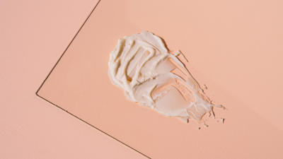 Schmidt's Hemp Seed Oil Deodorant texture sample on glass with peach backdrop